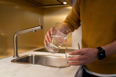 Someone pouring a glass of water